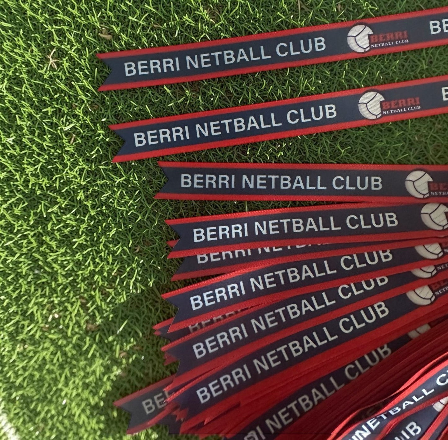 Multiple Berri Netball Club branded ribbons on grass