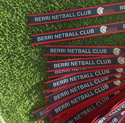 Multiple Berri Netball Club branded ribbons on grass