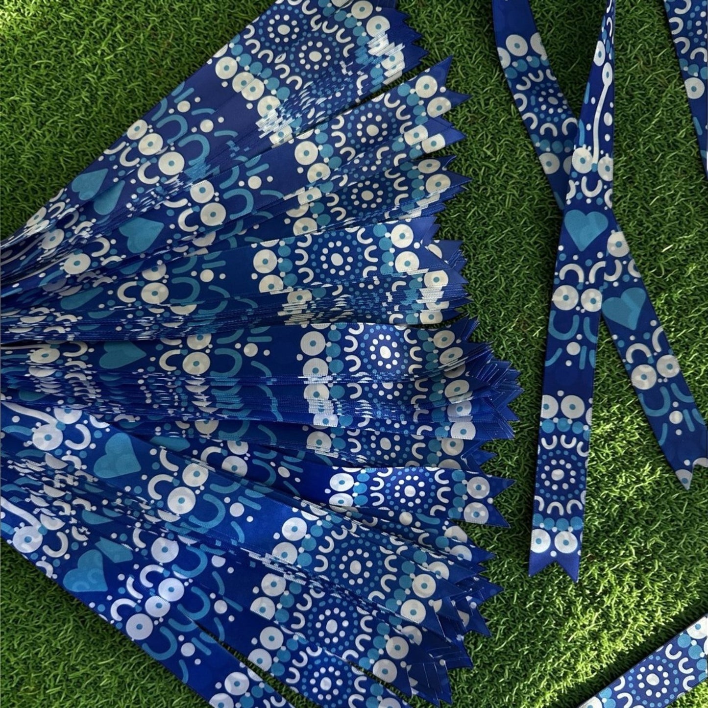 Blue and white patterned ribbon on a green grass background