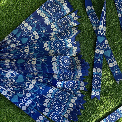 Blue and white patterned ribbon on a green grass background