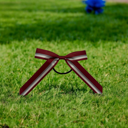 Maroon and white striped bow on grass