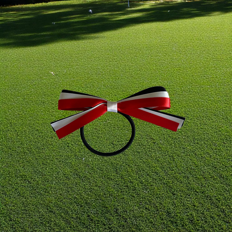 Red, white, and black bow on a green grass background