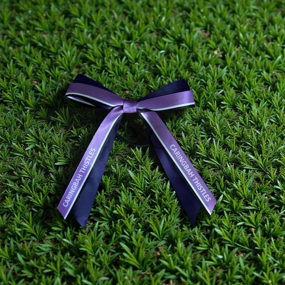 Purple ribbon with Netball' branding on grass