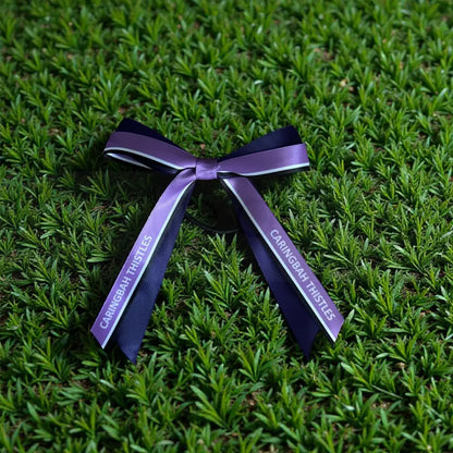 Purple ribbon with Netball' branding on grass