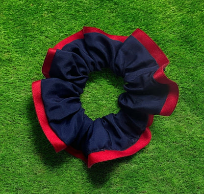 Navy and red scrunchie on green grass