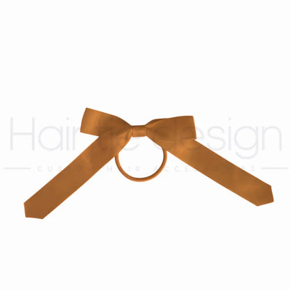 A gold satin ribbon tied into a bow with a central loop, shown against a plain white background.